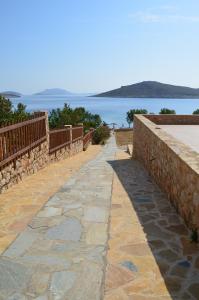 a stone walkway next to a wall with the ocean at Villa Aristoteles in Halki