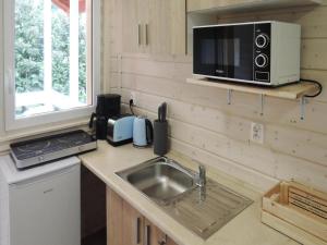 eine Küche mit Spüle und Mikrowelle in der Unterkunft Bungalow in Kolczewo near Baltic Sea & Lakes in Kołczewo