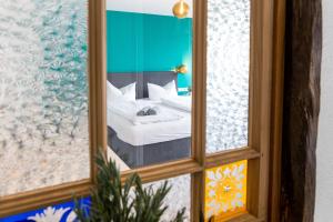 a mirror reflection of a bed in a room at Apartments zum roten Lamm- Bad Krozingen by living TIMELESS in Bad Krozingen