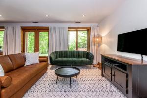 a living room with a couch and a television at Chalet HURON 15 Guest EV Car in Labelle