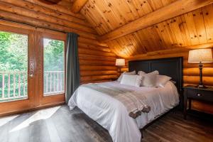 a bedroom with a bed in a log cabin at Chalet HURON 15 Guest EV Car in Labelle +53 photos