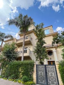 a building with a gate and a palm tree at Sela 1 in Cairo