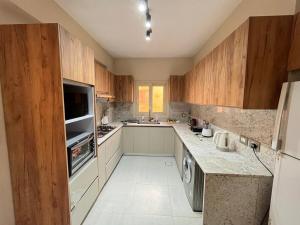 a large kitchen with wooden cabinets and a sink at Sela 1 in Cairo