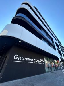 a building with a sign on the side of it at Premium Apartamenty Grunwaldzka 25A in Bydgoszcz