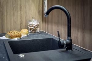 a kitchen counter with a sink with a sandwich on it at Premium Apartamenty Grunwaldzka 25A in Bydgoszcz +20 photos
