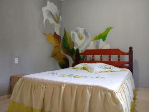 a bedroom with a bed with a flower mural on the wall at Apto n.09 condominio custo beneficio. in Brasília