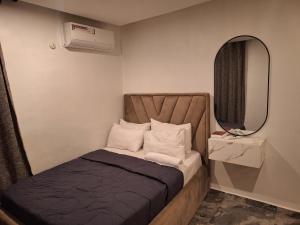 乌约NPJ Luxury Serviced Apartments的一间带床和镜子的小卧室