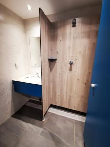 a bathroom with a sink and a wooden wall at Caravane 4 personnes au camping d'Aussois in Aussois +23 photos