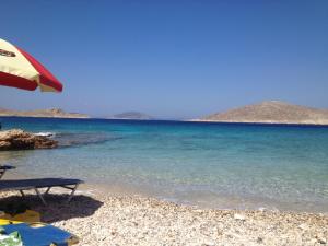 a beach with an umbrella and the ocean at Villa Aristoteles in Halki