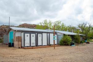 a small building with white doors and a roof at D2 Dino Dome- 2 Dbl Beds - Pet friendly in Drumheller