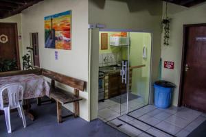 a small kitchen with a table and a glass door at Pousada garopaba in Garopaba +20 photos