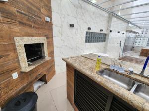 a bathroom with a sink and a shower with a fireplace at Cobertura com churrasqueira Pitangueiras 3 quartos frente ao mar in Guarujá +25 photos