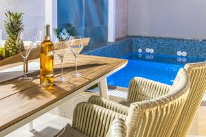 a table with glasses and a bottle of wine at Kallisti Palace - Private Pool with Hydromassage in Kissamos +52 photos