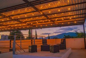 a patio with lights and chairs under a pergola at Hotel Villa Veral in San Sebastian Xolalpa