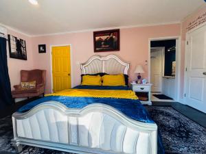 una camera da letto con un grande letto bianco con cuscini gialli di Entire Private 1BR Home for Travelers, Families, Work & Long Stays with Fast WiFi a Norcross