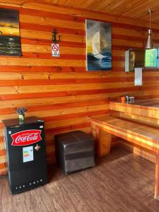 a log cabin with a bench and a soda machine at Algarrobo Lodge in Algarrobo +44 photos