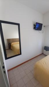 a mirror on a wall in a room with a bed at Noche Serena in Puerto Madryn