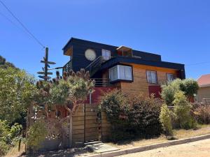 a house with a clock on top of it at Algarrobo Lodge in Algarrobo