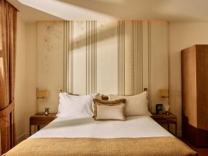 ein Schlafzimmer mit einem großen Bett mit weißen Laken und Kissen in der Unterkunft Hotel El Pilar Andalucia in Estepona