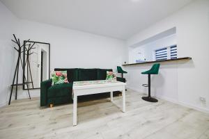 een woonkamer met een groene bank en een tafel bij Wesoła Centrum in Suwałki