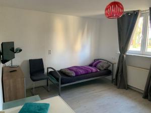a room with a bed and a chair and a window at Ferien- und Monteurwohnungen Wendischbrome in Jübar