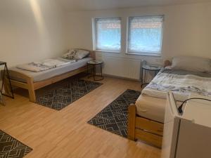 a bedroom with two beds and two windows at Ferien- und Monteurwohnungen Wendischbrome in Jübar