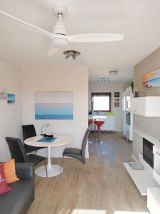 ein Wohnzimmer mit Tisch und Stühlen und einer Couch in der Unterkunft Bahia Sol Deluxe in Caleta de Fuste