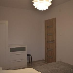 a bedroom with a bed and a dresser and a chandelier at Second Floor Apartment in Praid +13 photos