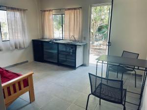 a kitchen with a counter and a table and chairs at Bungalo en Valle de Guadalupe in Ensenada