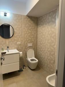 a bathroom with a toilet and a sink and a mirror at CityCenter Heart - Ultracentral & Panoramic View in Reşiţa +6 photos