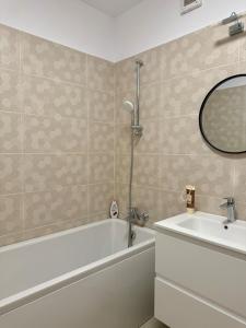 a bathroom with a tub and a sink and a mirror at CityCenter Heart - Ultracentral & Panoramic View in Reşiţa