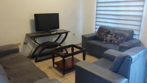 ein Wohnzimmer mit Sofa und Fernseher in der Unterkunft Casa 915 in Ciudad Juárez