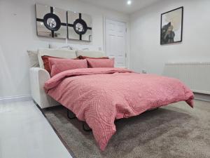 a bedroom with a pink blanket on a bed at StayZen Apartments - Private Garden & Free Parking Ground Floor Central Woking - Business & Leisure in Woking +24 photos