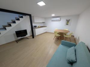 a living room with a blue couch and a table at Casa do Adro in Meda