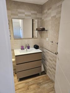 ein Badezimmer mit Waschbecken und Spiegel in der Unterkunft Bahia Sol Deluxe in Caleta de Fuste