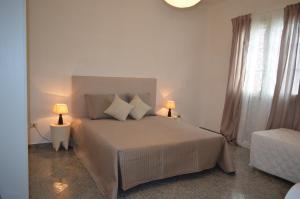 een slaapkamer met een bed met 2 lampen en een raam bij Villetta Summer in Porto Cesareo