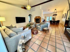 ein Wohnzimmer mit zwei Sofas und einem Fernseher in der Unterkunft Charming Spanish Heated Pool Spa Firepit Private Lovely Mountain Views in La Quinta
