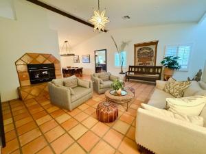 ein großes Wohnzimmer mit Sofas und einem Kamin in der Unterkunft Charming Spanish Heated Pool Spa Firepit Private Lovely Mountain Views in La Quinta