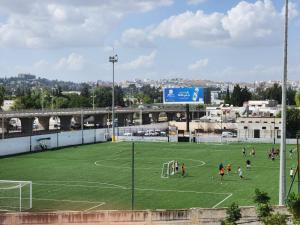 a group of people playing soccer on a soccer field at Ayoub Jus Station métro de Cité el Khadra in Tunis