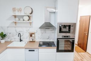 a white kitchen with a stove and a microwave at Apartment Friday in Travnik