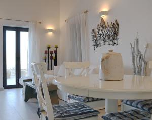 a white dining room with a white table and chairs at Villa Aristoteles in Halki