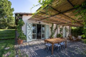 a patio with a table and chairs under a pergola at Vigna Luisa Resort - Near Rome in Genzano di Roma