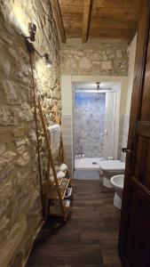 a stone bathroom with a toilet and a sink at Il Richiamo della Cascata in Papigno