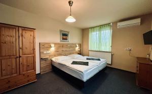 a bedroom with a large bed with a wooden headboard at La Villa Pergola in Szentgotthárd
