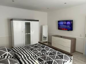 a bedroom with a bed and a tv on the wall at Haus Sösetal in Osterode am Harz in Osterode +21 photos