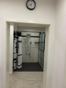 a bathroom with a clock on the wall and a mirror at Haus Sösetal in Osterode am Harz in Osterode