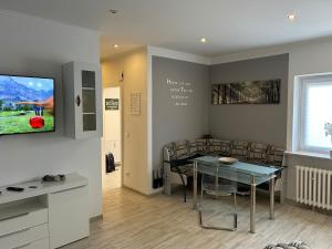 a dining room with a table and a television on a wall at Haus Sösetal in Osterode am Harz in Osterode