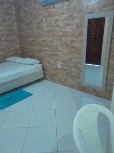 a small room with a bed and a mirror at Chalés Luz do Luar in Aracati