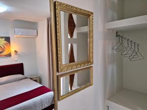 a mirror hanging on a wall next to a bed at Modern Quiet Apartment in the Center of Rhodes in Rhodes Town