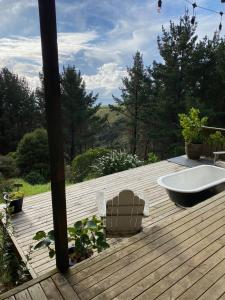 a bath tub sitting on top of a wooden deck at Raglan LoveNest -Romantic escape with outdoor bath in Raglan